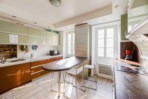 una cocina con mesa y algunas sillas. en Le Doolie's Biarritz - Siquijor Habitación privada - Jardín - Salón, en Biarritz
