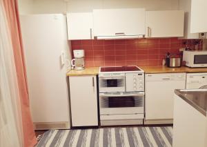 - une cuisine avec des appareils blancs et du carrelage rouge dans l'établissement Lilla Huset, à Stöllet