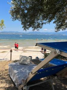 a blue bed on a beach with people in the water at Hotel Casa Scaligeri in Sirmione