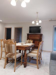 une salle à manger avec une table, des chaises et une télévision dans l'établissement Eldorado, à Białystok