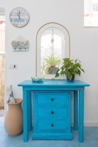 a blue dressing table with a mirror and a plant at La Bella Annacapri in Anacapri
