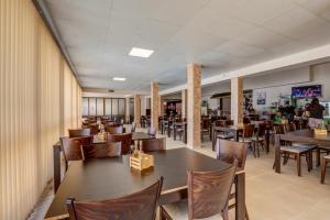 a dining room with tables and chairs in a restaurant at Camping Saint George in Topola
