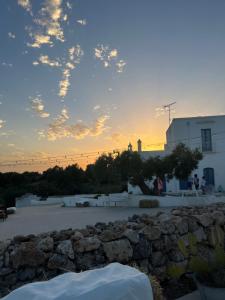 una puesta de sol sobre un edificio y una pared de piedra en La Casa Di Gioia, en Mottola