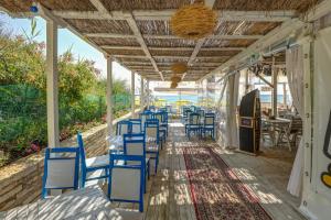 a row of blue chairs and tables on a patio at Camping Saint George in Topola