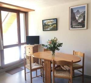 uma mesa de jantar com um vaso de flores em Studio St Lary proche du centre, au calme avec vue montagne em Saint-Lary-Soulan