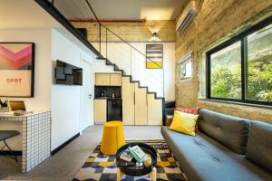 ein offenes Wohnzimmer mit einem Sofa und einer Treppe in der Unterkunft Pixel Hotel - Rooftop & Spa in Tel Aviv + 38 Fotos