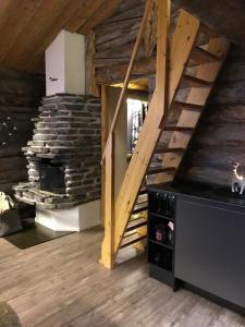 a living room with a staircase and a fireplace at Iso-Syötteen Kelokolo Soarvesalvu in Syöte