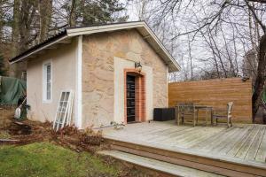 a small house with a wooden deck with a table at Studio house in quiet area in Stocksund