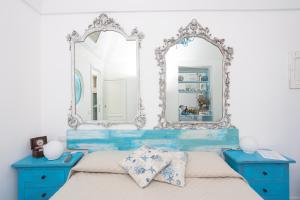 a blue bedroom with two blue tables and a mirror at La Bella Annacapri in Anacapri