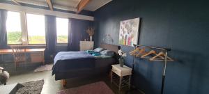 DverbergSolheim Guesthouse的蓝色卧室配有一张床和一张书桌