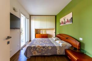 a bedroom with a bed and a green wall at L'Ospitale appartamento in Peschiera del Garda