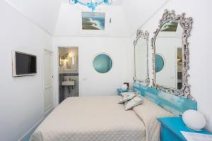 a bedroom with a bed with a mirror on the wall at La Bella Annacapri in Anacapri