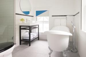 a bathroom with a white tub and a sink at The Chequit in Shelter Island Heights +14 photos