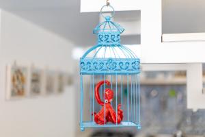a blue bird cage with two red birds in it at La Bella Annacapri in Anacapri