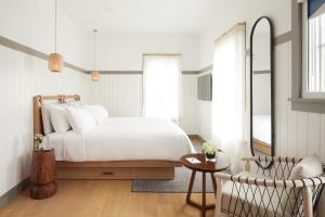 a bedroom with a bed and a table and a mirror at The Chequit in Shelter Island Heights