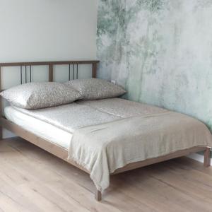 Bett in einem Schlafzimmer mit Holzboden in der Unterkunft Apartamenty Heweliusz House in Stegna