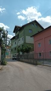 a green building with a car parked in front of it at Guesthouse Mema in Sarajevo