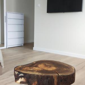 una mesa de centro hecha de un tronco de árbol en Apartamenty Heweliusz House en Stegna