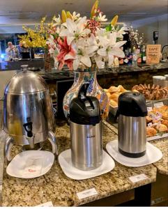 eine Theke mit zwei Kaffeemaschinen und einer Vase aus Blumen in der Unterkunft The Time Flat - Berrini - 200 metros do WTC in São Paulo