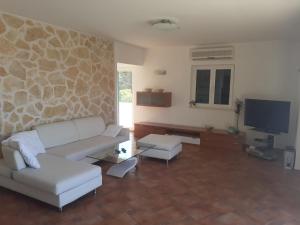 a living room with a couch and a tv at Apartments Iličić in Supetar