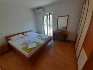 a bedroom with a large bed and a mirror at Apartments Iličić in Supetar