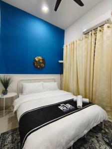 a bedroom with a blue wall and a bed at RUMAH AINA Homestay Bukit Changgang Private Pool in Kampong Melot