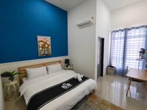 a bedroom with a large bed with a blue wall at RUMAH AINA Homestay Bukit Changgang Private Pool in Kampong Melot +26 photos