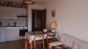 a kitchen with a table and chairs and a kitchen with a couch at Studio belle vue sur les montagnes in Le Grand-Bornand