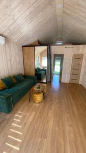 a living room with a green couch and a table at Chill House in Anykščiai