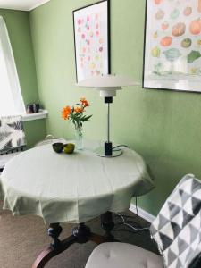 une table avec une lampe et un vase de fleurs sur elle dans l'établissement B & B Mølgaard by Skjern, à Skjern