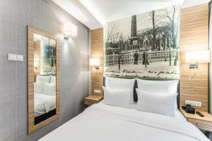 una camera d'albergo con un letto e una foto della torre Eiffel di Hotel Wieniawski a Lublino