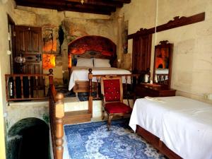 Halfeti的住宿－TÜRKMEN KONAGI HALFETİ BUTİK OTEL，一间卧室设有两张床和一个壁炉