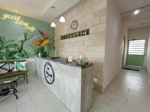 um lobby com um balcão com flores na parede em La Maja Suites em Villahermosa