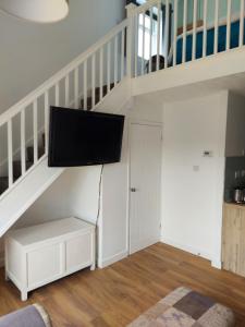 a living room with a flat screen tv on a wall at 1 Bedroom House with Garden and off road private parking in Peterborough
