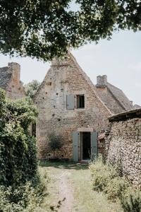 um antigo edifício de pedra com uma porta e uma janela em Maison d'hôtes Bel Estiu em Saint-Geniès