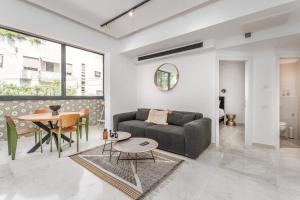 a living room with a couch and a table at Gordon area - Deluxe 2bdr close to the beach in Tel Aviv