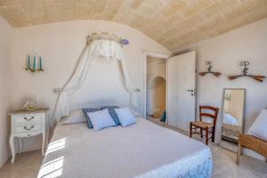 - une chambre avec un lit, une chaise et un miroir dans l'établissement Villa Trullo Didi by Villa Plus, à Ceglie Messapica
