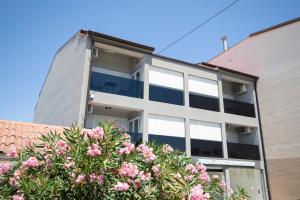 an apartment building with pink flowers in front of it at Residence Panorama in Medulin