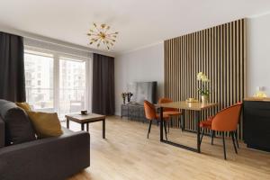 - un salon avec un canapé, une table et des chaises dans l'établissement Short Stay Apartments, à Gdańsk