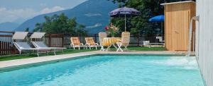 - une piscine avec des chaises et un parasol dans l'établissement Residence Innerfarmerhof, à Tirolo