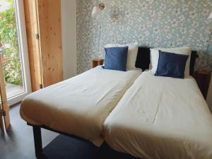 1 dormitorio con 2 camas y almohadas azules en B&B Biej' oons tuus en Hellendoorn