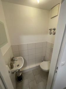 a small bathroom with a toilet and a sink at SCHLOSS & ALTSTADT - Modern & Stylish für 6 Küche in Dachau