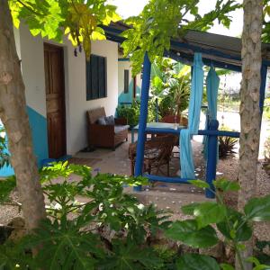 un porche de una casa con un cenador azul en Furaha B&B Kendwa, en Kendwa