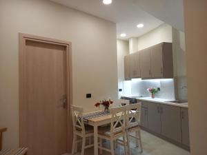 eine Küche mit Tisch und Stühlen in einem Zimmer in der Unterkunft Nebulous Apartment in Zakynthos