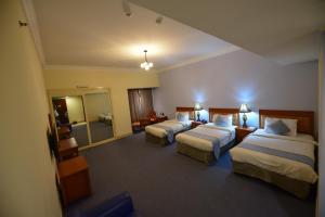 Llit o llits en una habitació de Grand Safir Hotel
