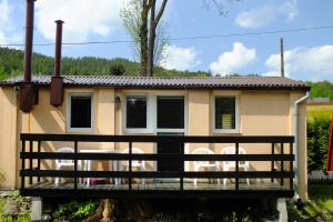 ein Haus mit Stühlen auf einer Holzterrasse in der Unterkunft Ośrodek Wypoczynkowy Beskid in Mienzebrosche