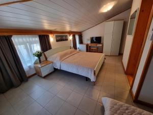 ein Schlafzimmer mit einem Bett und einem Fernseher in einem Zimmer in der Unterkunft Villa Riva in Omišalj