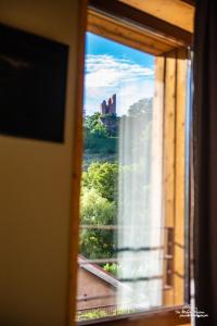 una ventana con vistas a un castillo a lo lejos en Logis Hôtel Altitude et Spa Pierre-Percée, en Pierre-Percée