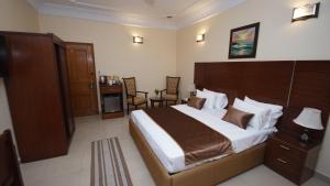 a bedroom with a large bed with a wooden headboard at World Inn Karachi in Karachi