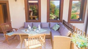 a patio with a couch and a table and chairs at Guest House Chepelare in Chepelare